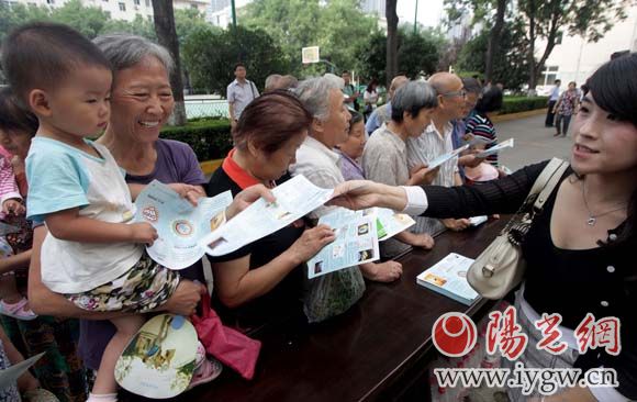 工作人員向市民發(fā)放環(huán)保知識(shí)讀本。